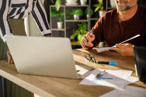 A woman and a man working together on credentialing paperwork in an office setting