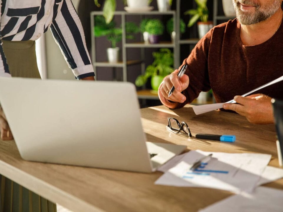 A woman and a man working together on credentialing paperwork in an office setting